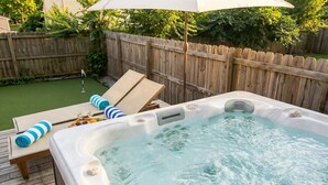 A hot tub on a wooden deck with lounge chairs and an umbrella. - Nashville sleeps 24: 2 homes, hot tub & game room near broadway (Nashville)