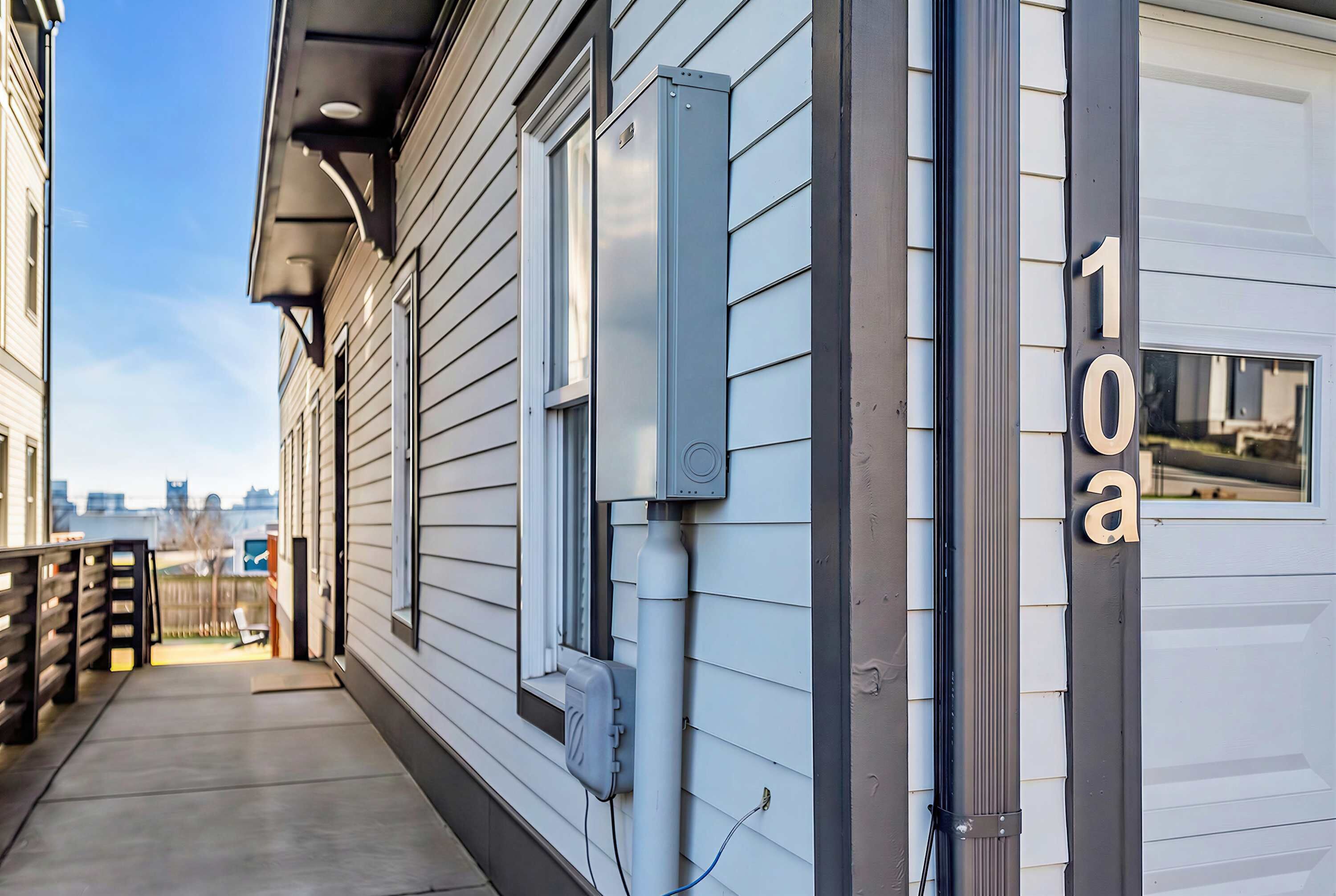 A residential building with a garage door, a mailbox, and a clear sky.
