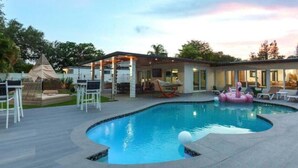 A swimming pool with a modern house in the background. - Athletic Villa Football Field Gym Cinema (North Miami)