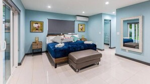 A modern bedroom with a large bed, a bedside table, a bench, and a mirror. - Athletic Villa Football Field Gym Cinema (North Miami)