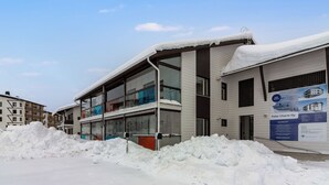 Un bâtiment moderne doté de grandes fenêtres et d’un toit recouvert de neige.