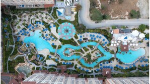 An aerial view of a resort with multiple swimming pools, lounge areas, and a parking lot. - Ocean View/Ocean Side  2BR at Aruba Surf Club – Steps to Palm Beach Paradise (Noord)