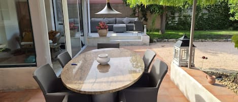 An outdoor patio with a round table, chairs, and a sofa.