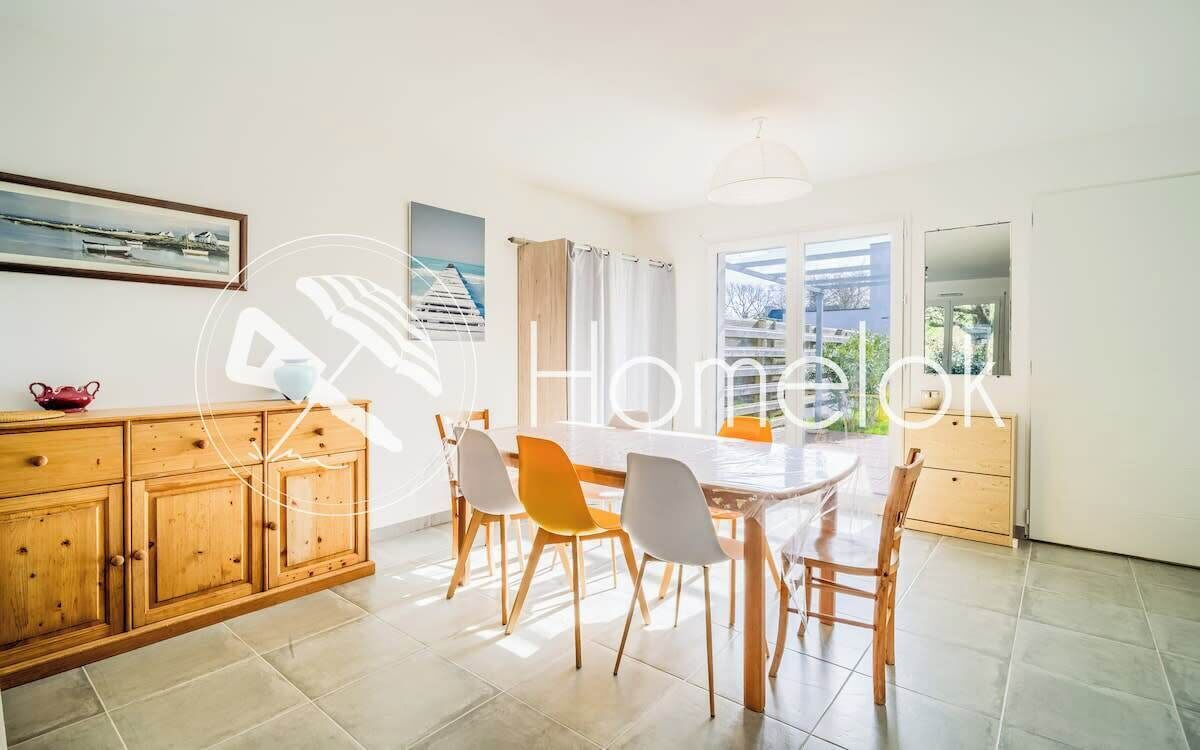 A bright dining area with a wooden cabinet, a round table, and six chairs.