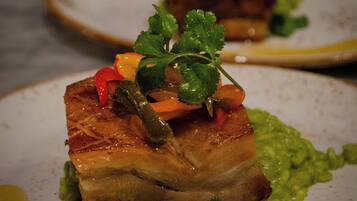 Plat amb carn coberta de verdures i guarnició d'herbes aromàtiques.