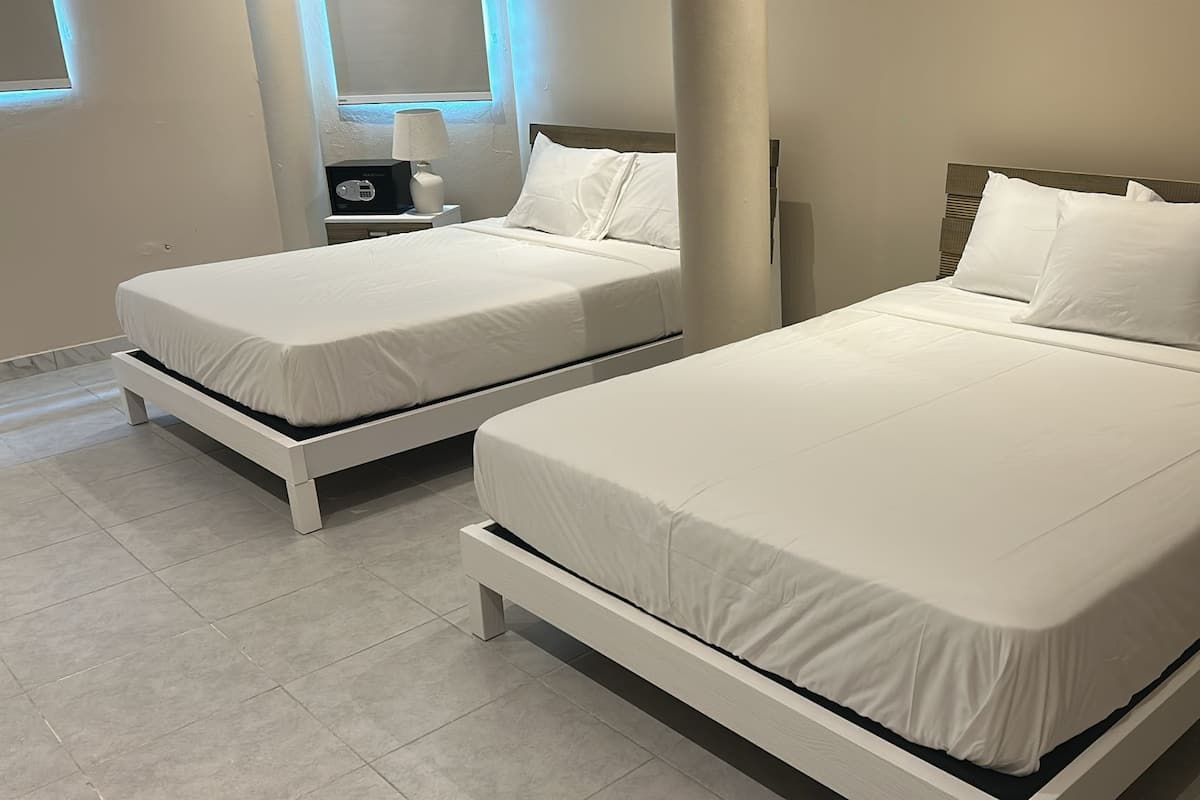 Two single beds with white bedding in a hotel room.