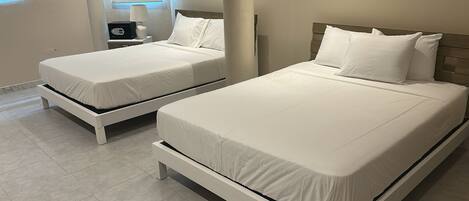 Two single beds with white bedding in a hotel room.