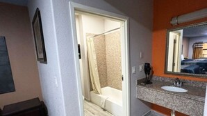 Une salle de bain avec une douche, un lavabo et un miroir.