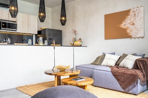 Un espace de vie moderne comprenant une cuisine, un canapé et une table basse.