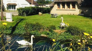 Une maison avec un toit de chaume et un bâtiment blanc avec un toit recouvert de tuiles.