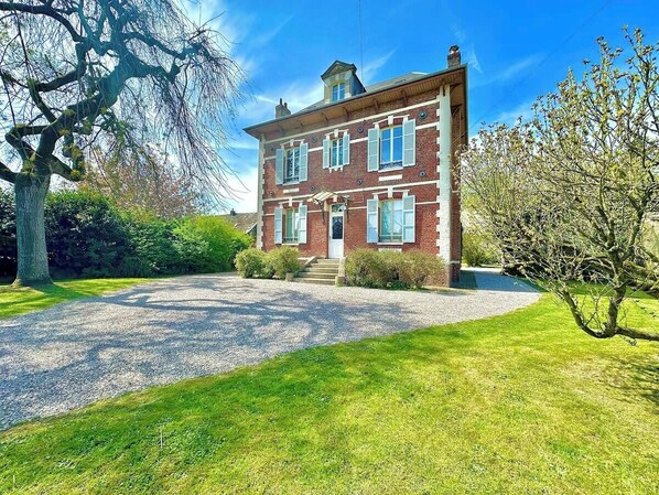 A two-story brick building with a gravel driveway and a well-maintained lawn. - La Villa Dorange, 15 min from the beach- Famille-Amis (Sailly-Flibeaucourt)