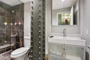Ein modernes Badezimmer mit Dusche, Toilette und Waschbecken.