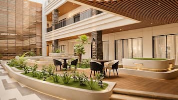 A modern indoor courtyard with a pool, seating area, and plants.