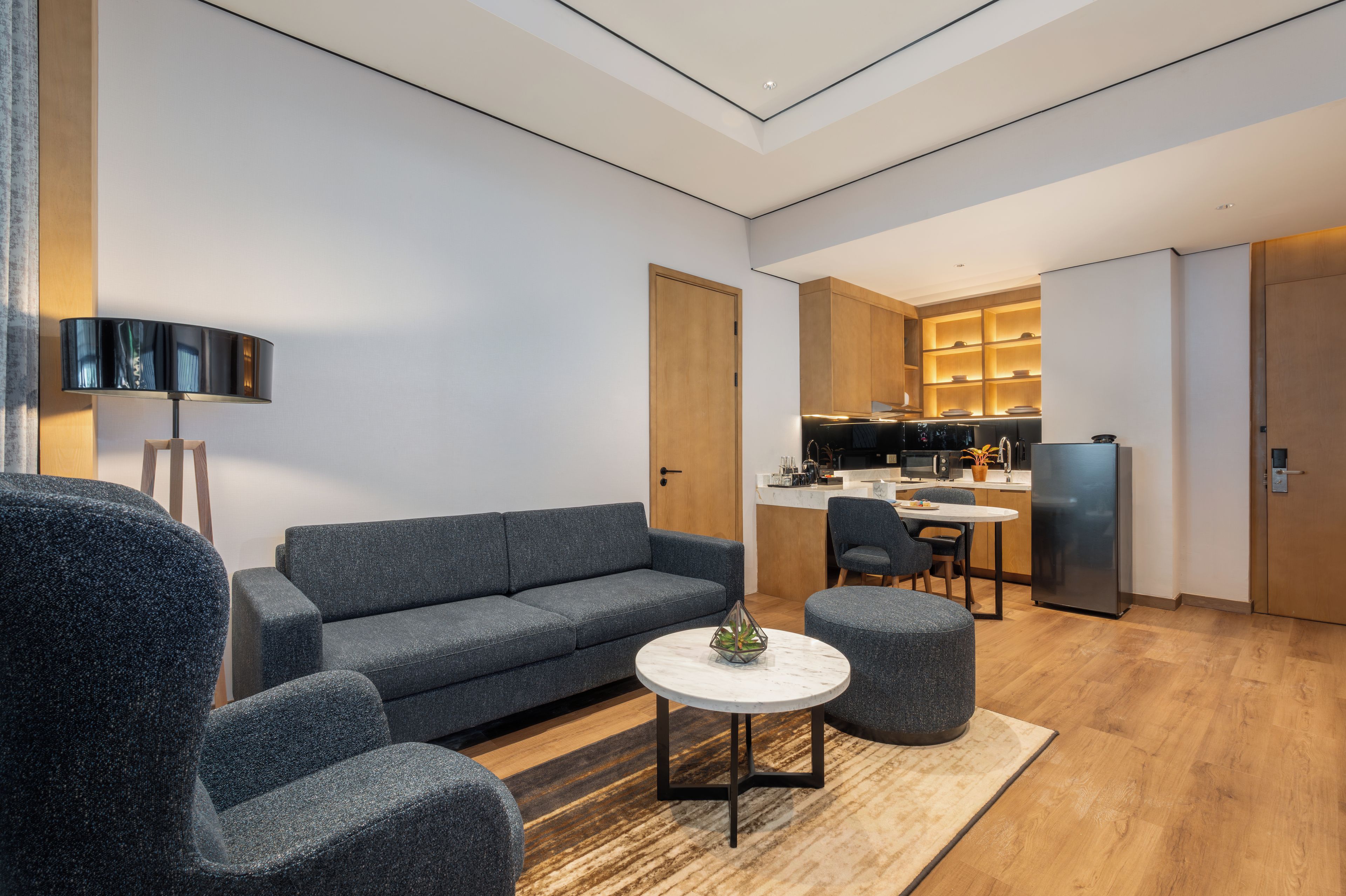 A modern living room with a sofa, armchairs, a coffee table, and a TV.