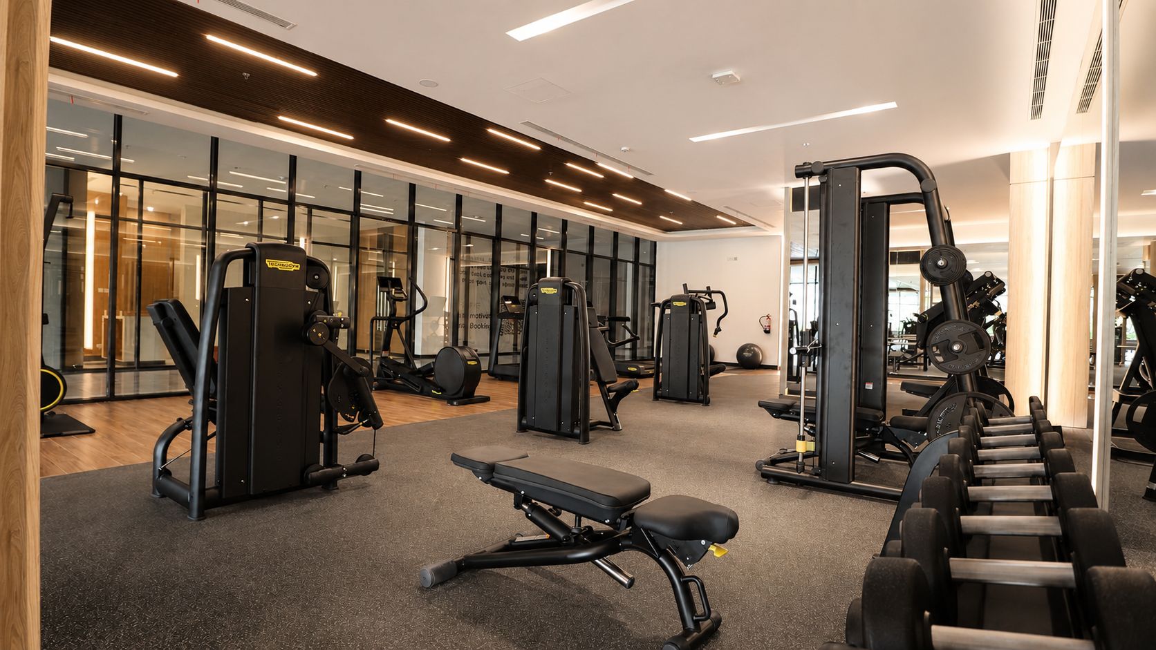 A gym with various exercise equipment, including treadmills, weight machines, and free weights.