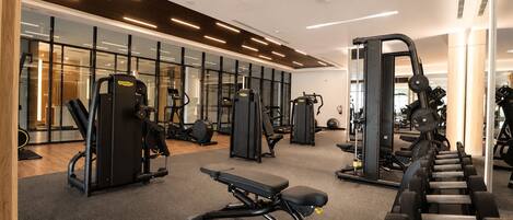 A gym with various exercise equipment, including treadmills, weight machines, and free weights.