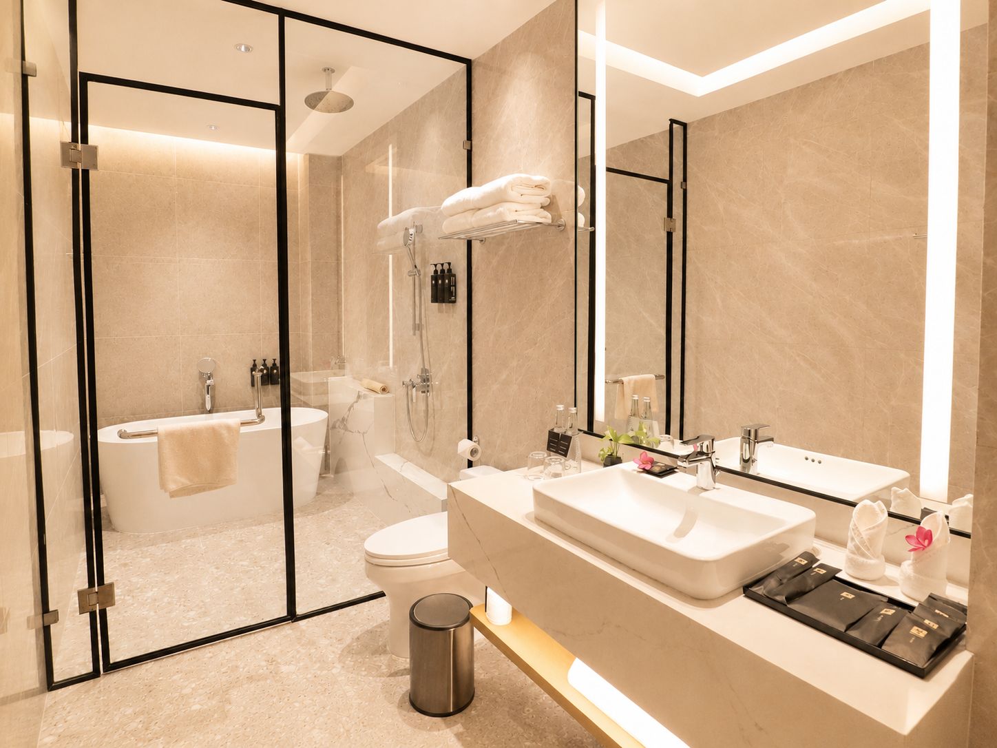 Une salle de bain moderne dotée d’une douche à parois de verre, d’une baignoire, de toilettes et d’un meuble-lavabo avec un grand miroir.