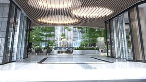 Un hall d’entrée moderne doté d’un élément décoratif central en eau, d’espaces aménagés pour s’asseoir et d’une vue sur une cascade.