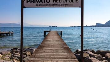 Eine Holzstege führt zu einer privaten Heliopolis mit freiem Blick auf das Wasser und die entfernten Berge.