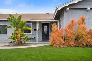 A residential house with a front door, a small porch, and a well-maintained lawn. - Cozy Clean Family Home - Central to everything! (San Diego)