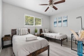 A bedroom with two beds, a ceiling fan, a window with blinds, and a vase with pampas grass. - Cozy Clean Family Home - Central to everything! (San Diego)