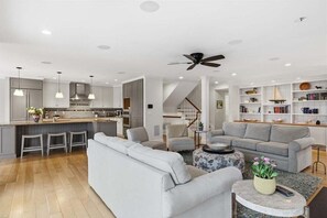 A modern kitchen with grey cabinets, a central island, and pendant lighting.