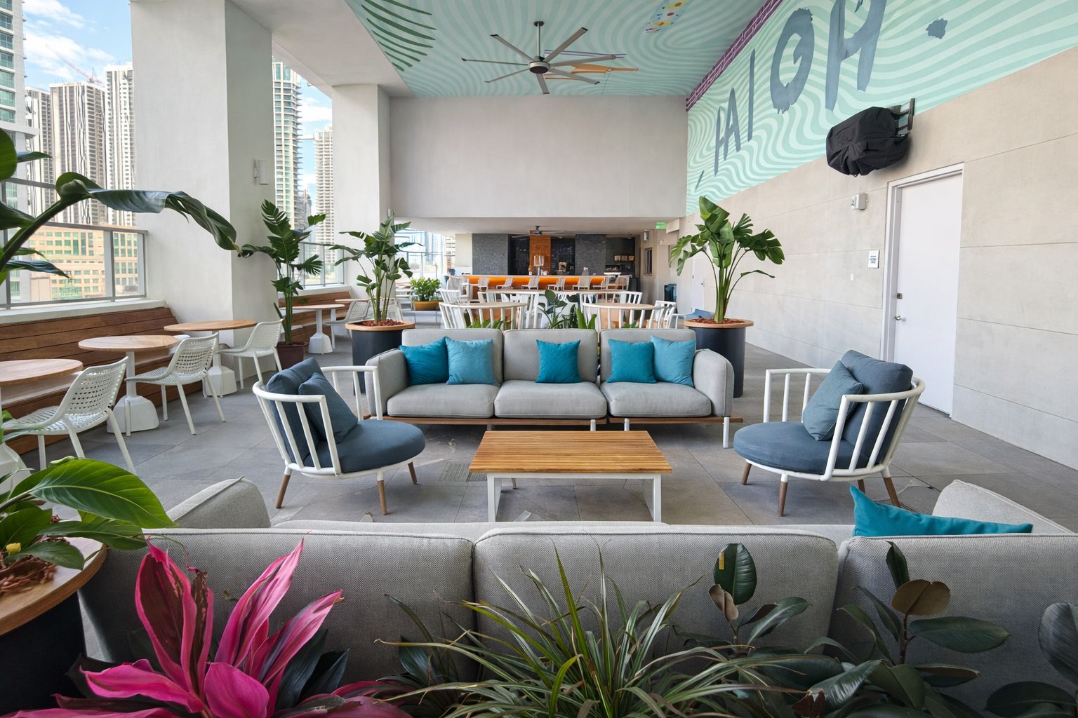 A modern lounge area with a sofa set, chairs, and tables, surrounded by potted plants.