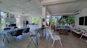 Een ruime woonkamer met keuken, eettafel en zithoek.
