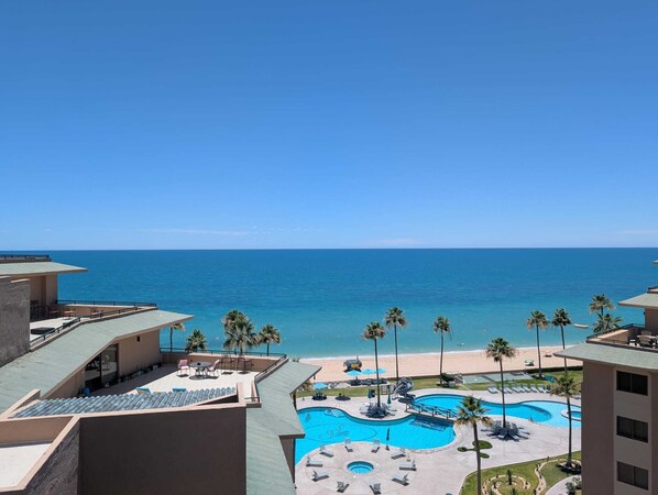 Ein Resort mit Pool, Liegestühlen und Meerblick.