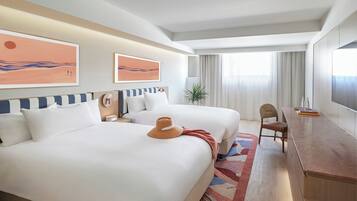 Une chambre d’hôtel avec un grand lit, un bureau, une chaise et une fenêtre avec des rideaux.