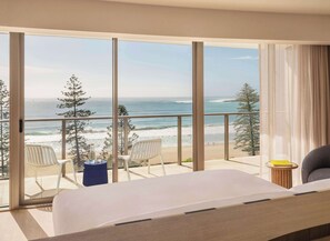 A hotel room with a large balcony, a bed, two chairs, and a small table. - Avani Mooloolaba Beach Hotel (Mooloolaba)