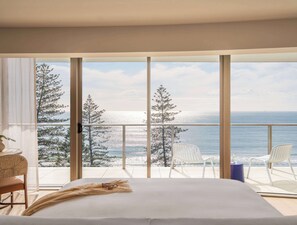 A bedroom with a large window, a bed, a chair, and a small table. - Avani Mooloolaba Beach Hotel (Mooloolaba)