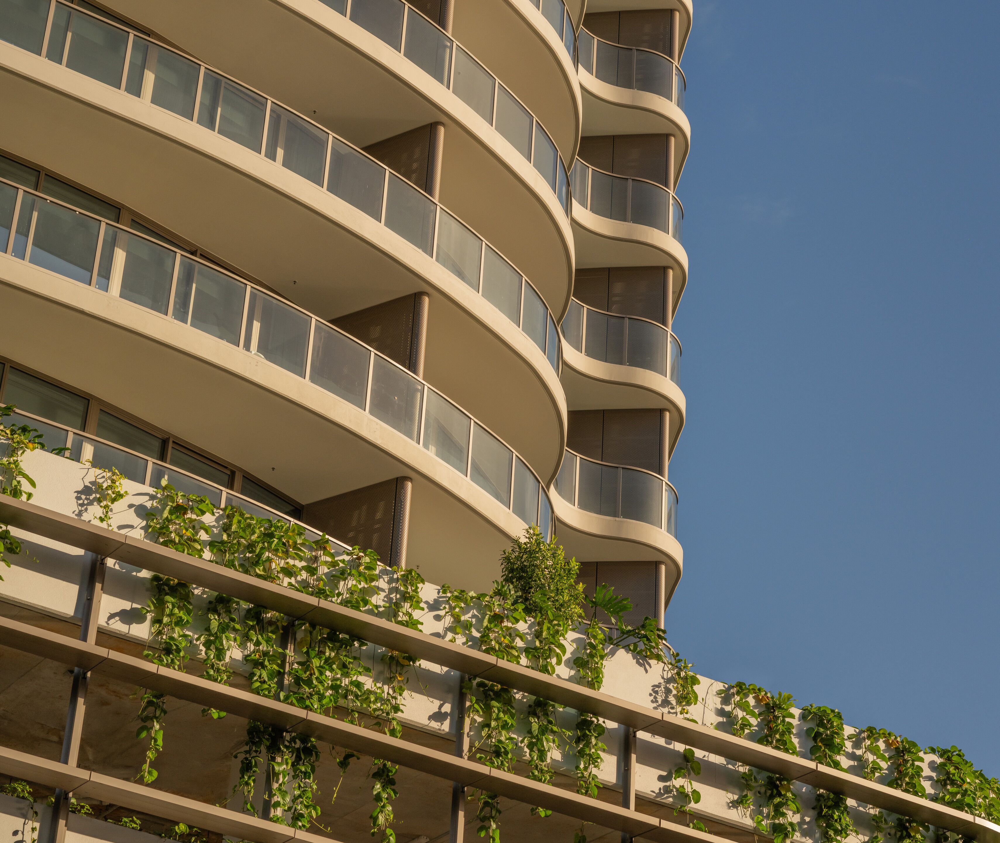 Un edificio de varios pisos con balcones y cielo despejado.