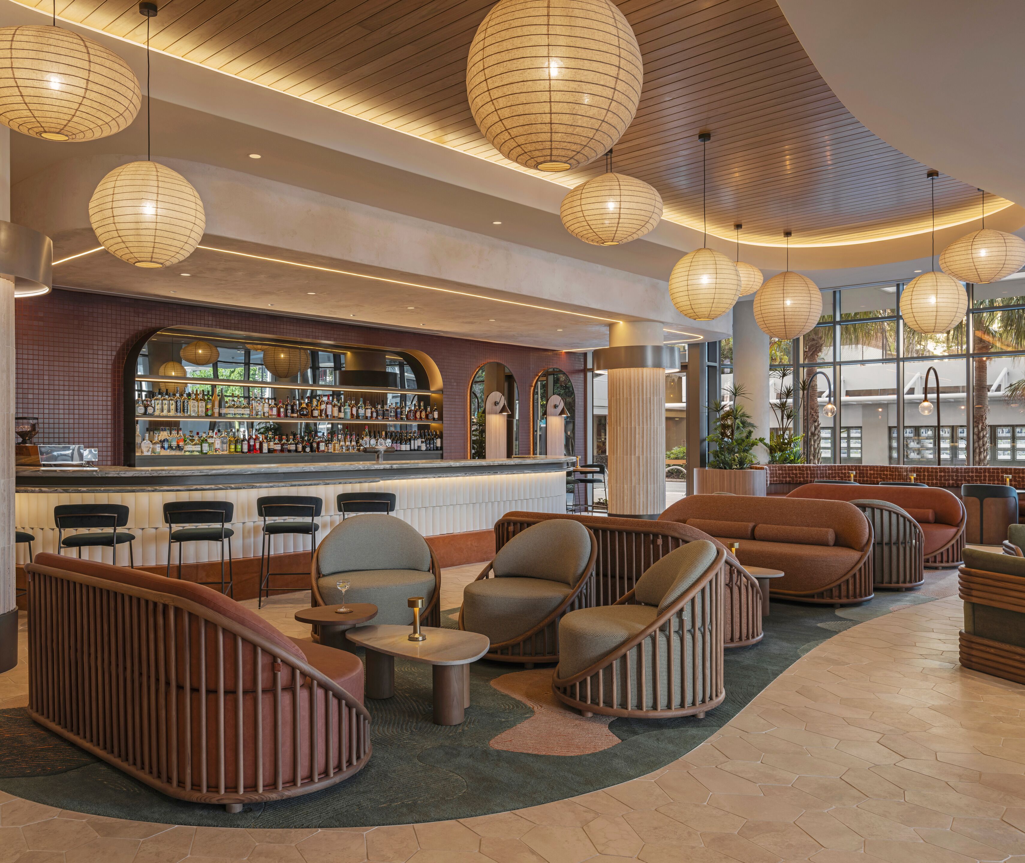 A modern bar area with seating and a variety of liquor bottles.