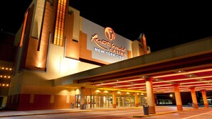 Een gebouw met een grote verlichte bord met daarop 'Resort World Casino New York City'.