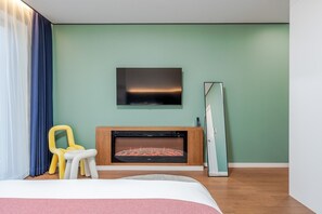 Una habitación moderna con chimenea, televisión de pantalla plana y una cama.