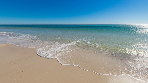 Ein Strand mit klarem Wasser und sandigem Ufer.