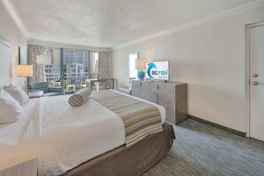 A hotel room with a large bed, a television, a desk, and a view of the city. - Amazing Ocean View,King Bed, Beautifully Decorated (Myrtle Beach)