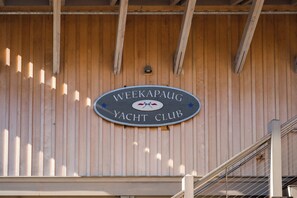 Una pared de madera con un letrero del Club de Yates Weekapaug.