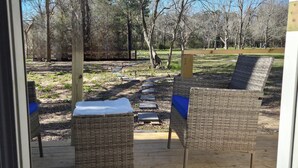 Un área de estar al aire libre con sillas de mimbre y una terraza de madera.