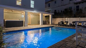 A swimming pool with a hot tub, outdoor seating, and a covered patio area. - NEW! The Crescent Surf -Pet Friendly Beach house firepit, tiki bar, pool & spa (St. Augustine)