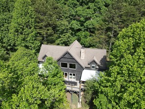 Ein zweistöckiges Haus mit Satteldach, umgeben von üppigem Grün.