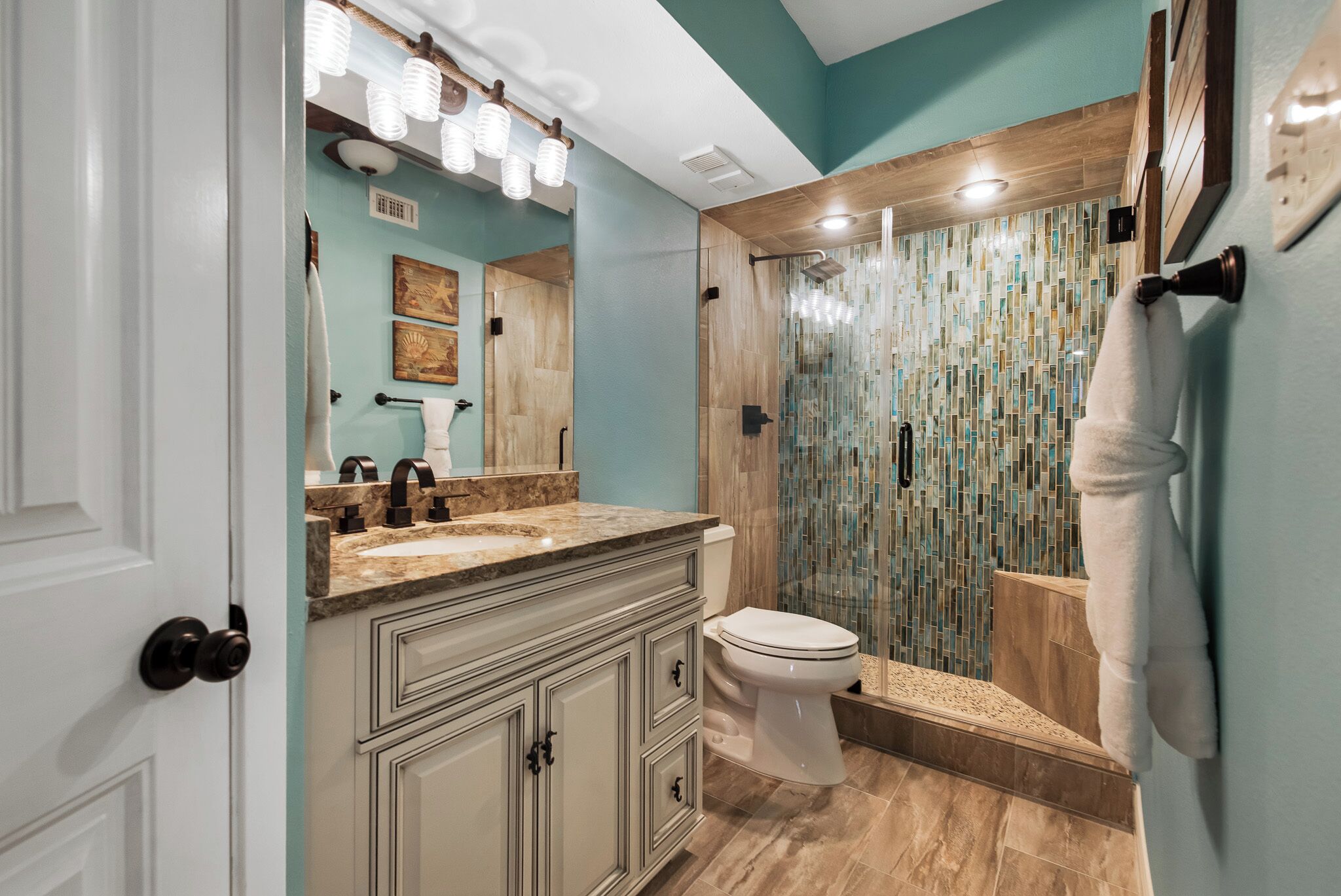 Une salle de bain équipée d’une douche, de toilettes et d’un meuble-lavabo avec un miroir.