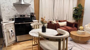 A modern kitchen with a stove, oven, and a dining area with a table and chairs.