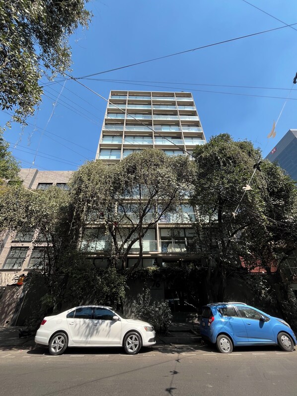 Um edifício com vários andares e design arquitetônico moderno, com telhado plano e grandes janelas.