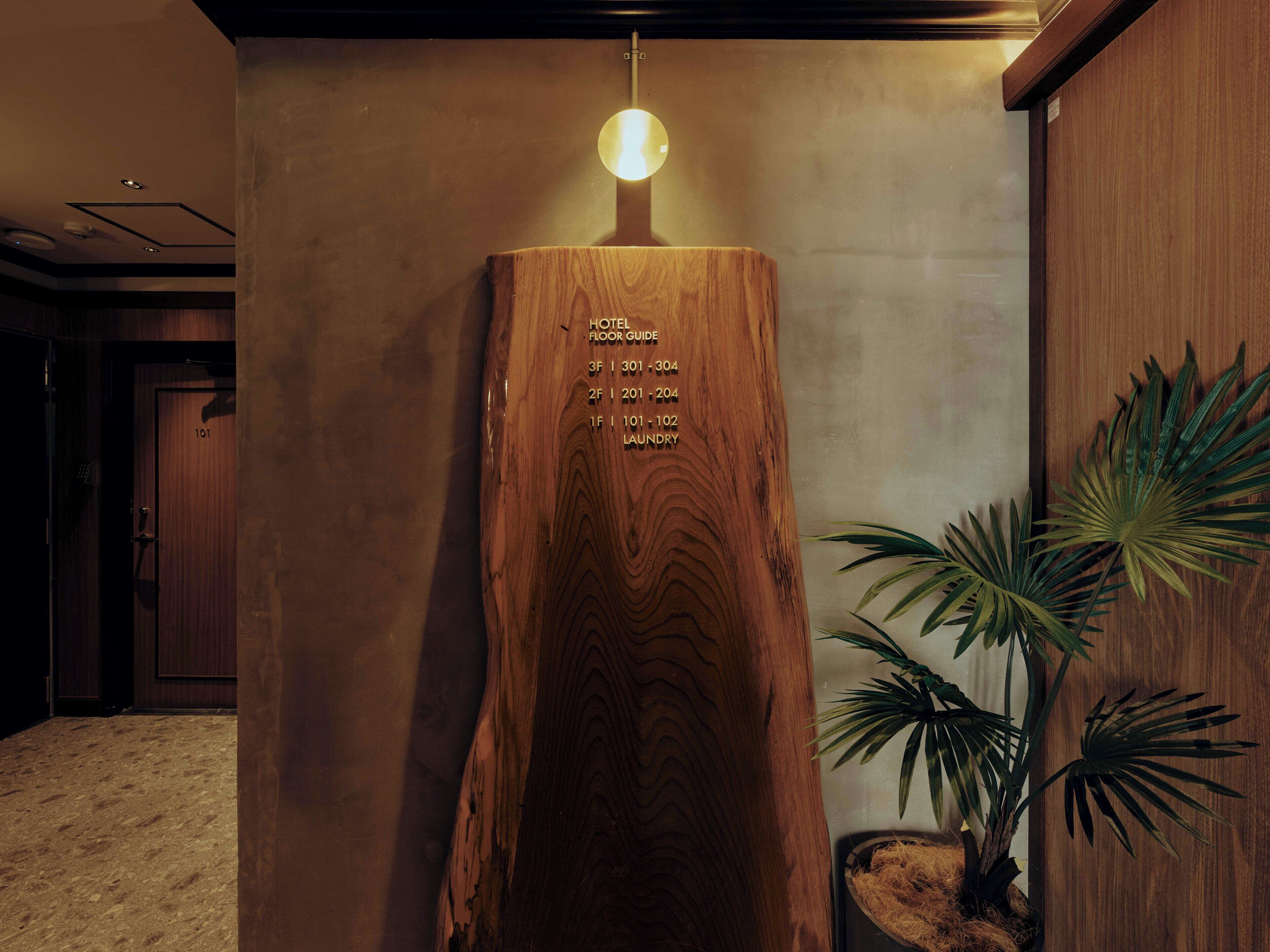 Una parete di legno con una guida ai piani dell'hotel e una pianta.