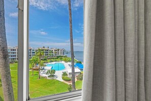 Blick auf ein Hotel mit Pool, Palmen und einem Gebäude im Hintergrund.
