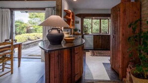 Una cocina rústica con armarios de madera, una olla grande y una lámpara colgante.