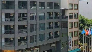 A multi-story building with a ground-level commercial space, large windows, and a flat roof.