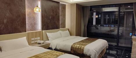 A hotel room with two beds, a large window, and a view of the city.